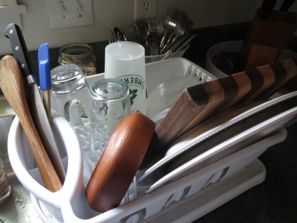 utensils, glasses, and dishes in white dish-drying rack